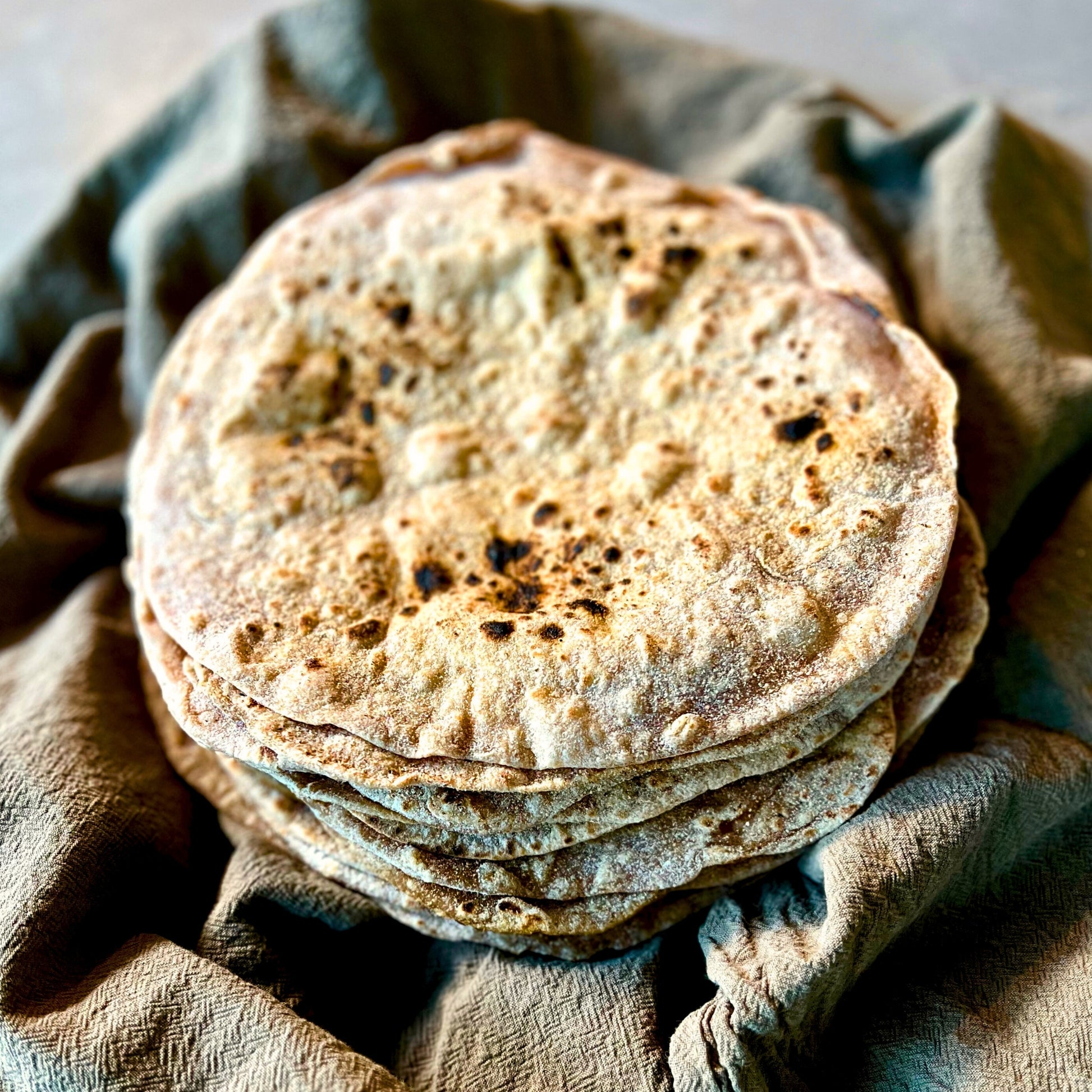 Spelt roti flatbreads stacked on a plate – bread delivery Northern Rivers